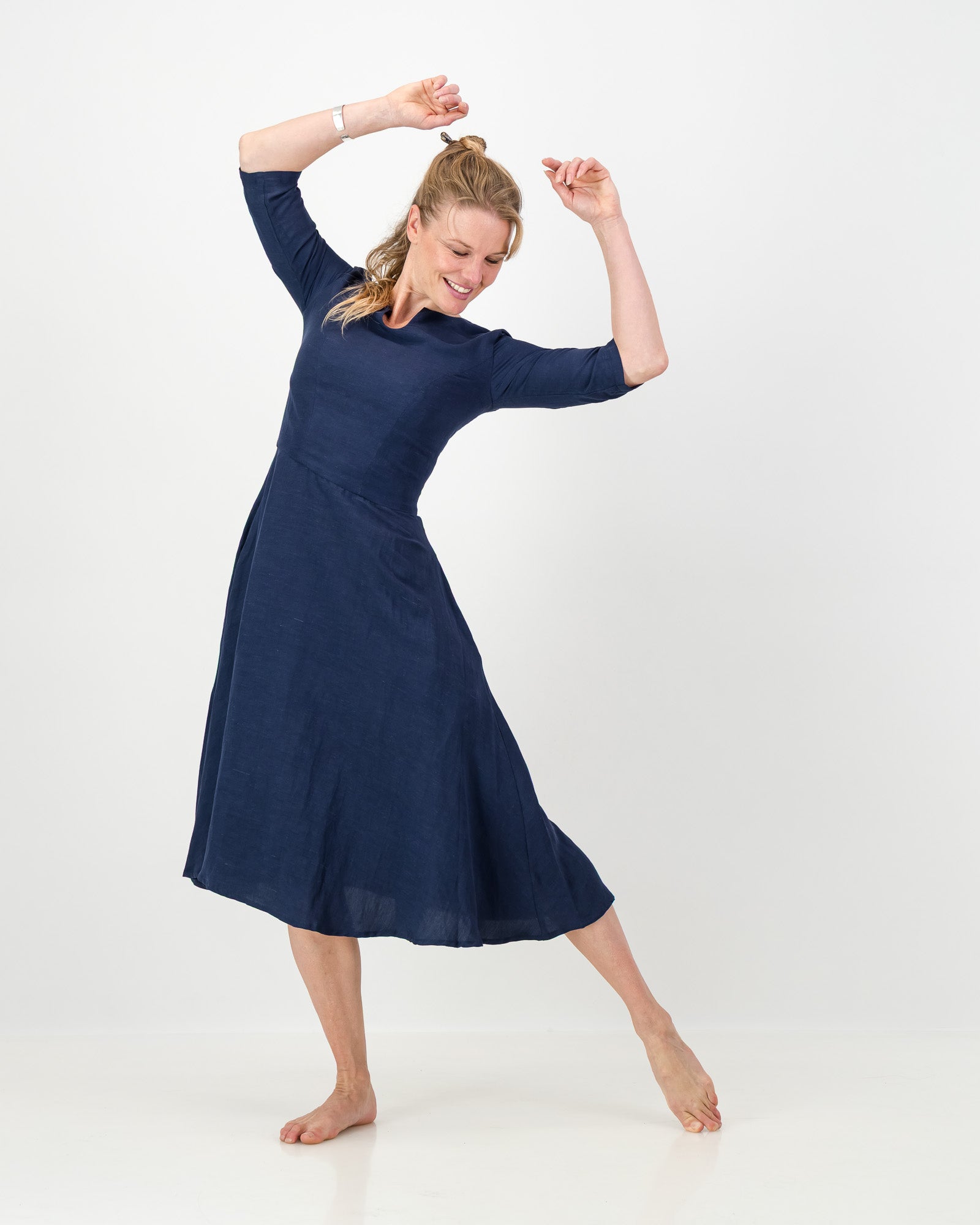 This image displays the LUNAR Khloe Dress in navy, highlighting its elegant and versatile design. The dress features a full, flattering knee-length skirt, a sophisticated keyhole neckline, and three-quarter sleeves, creating a stylish yet formal appearance.