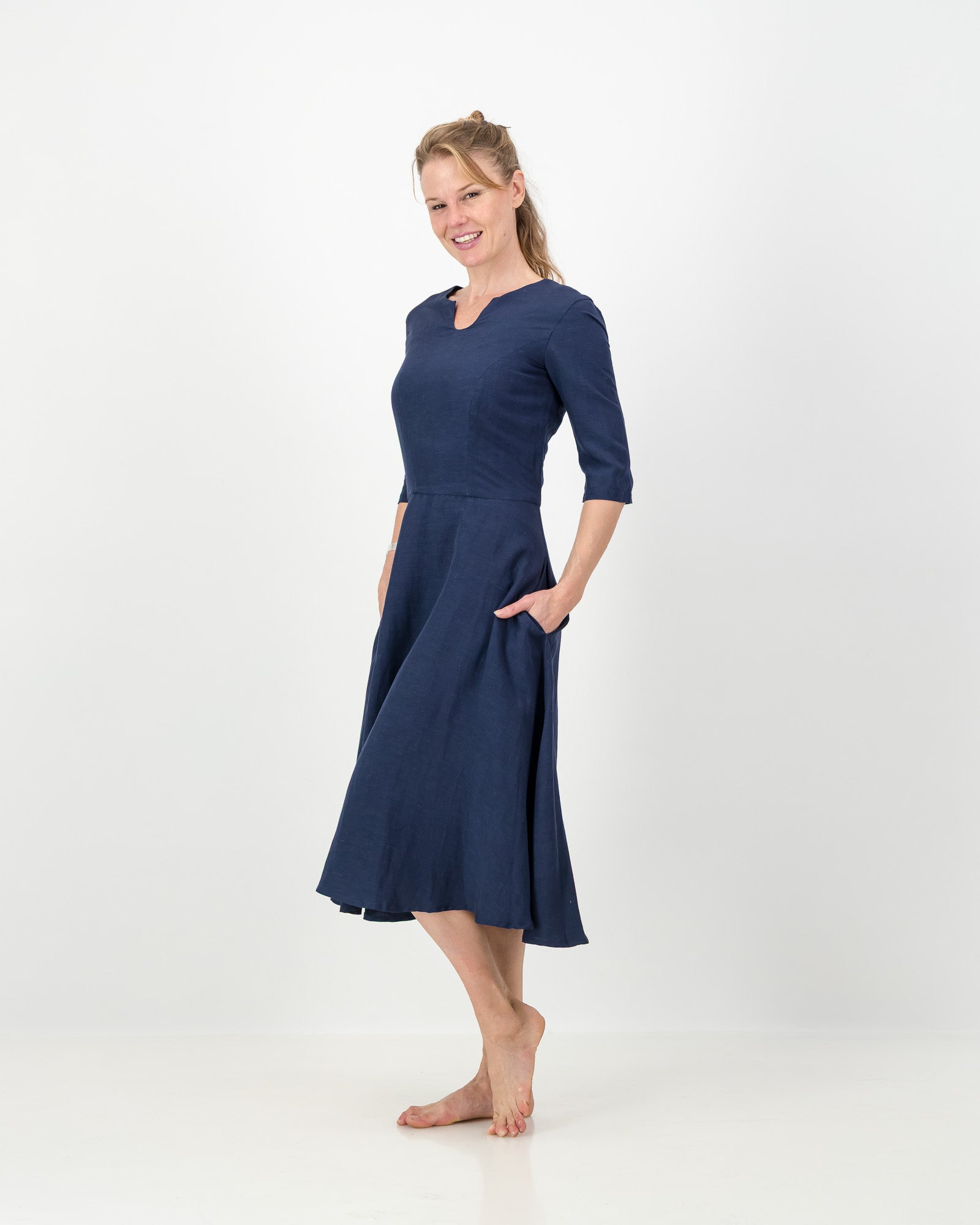 This image displays the LUNAR Khloe Dress in navy, highlighting its elegant and versatile design. The dress features a full, flattering knee-length skirt, a sophisticated keyhole neckline, and three-quarter sleeves, creating a stylish yet formal appearance.
