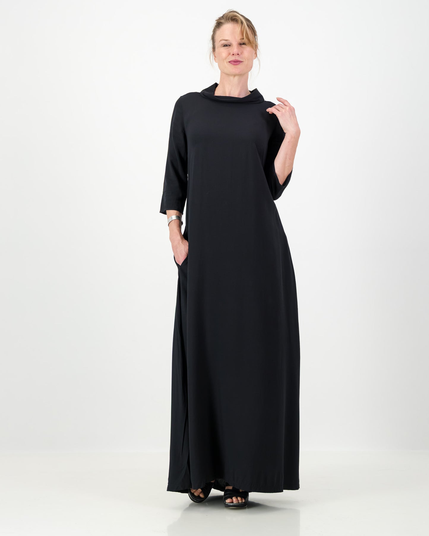 Woman wearing a long black dress on a white background