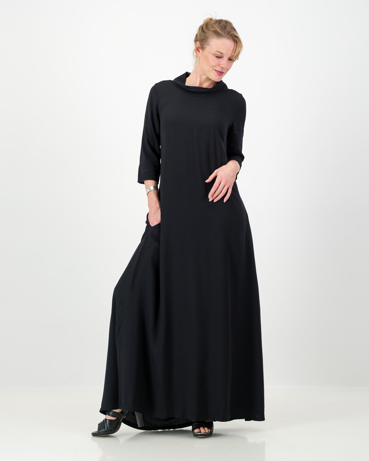 Woman wearing a long black dress on a white background