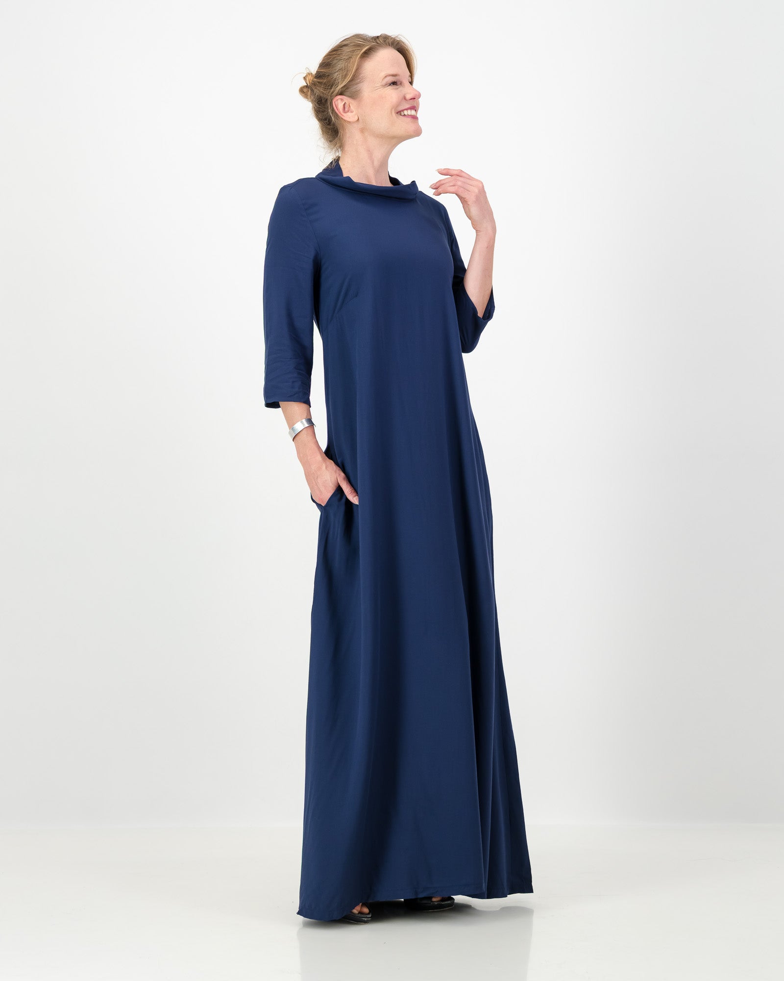 Woman wearing a long blue dress on a white background