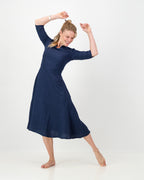 This image displays the LUNAR Khloe Dress in navy, highlighting its elegant and versatile design. The dress features a full, flattering knee-length skirt, a sophisticated keyhole neckline, and three-quarter sleeves, creating a stylish yet formal appearance.