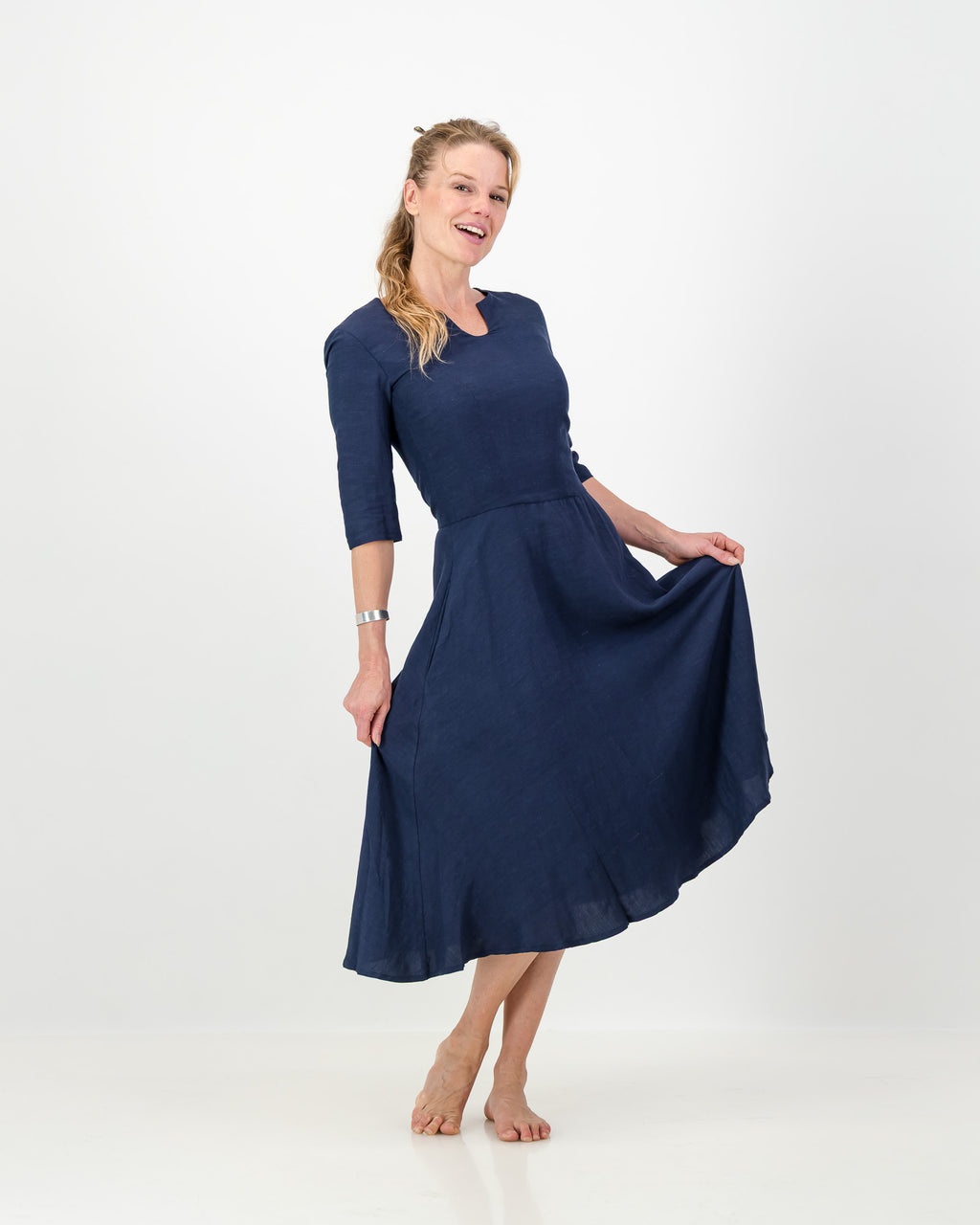 This image displays the LUNAR Khloe Dress in navy, highlighting its elegant and versatile design. The dress features a full, flattering knee-length skirt, a sophisticated keyhole neckline, and three-quarter sleeves, creating a stylish yet formal appearance.