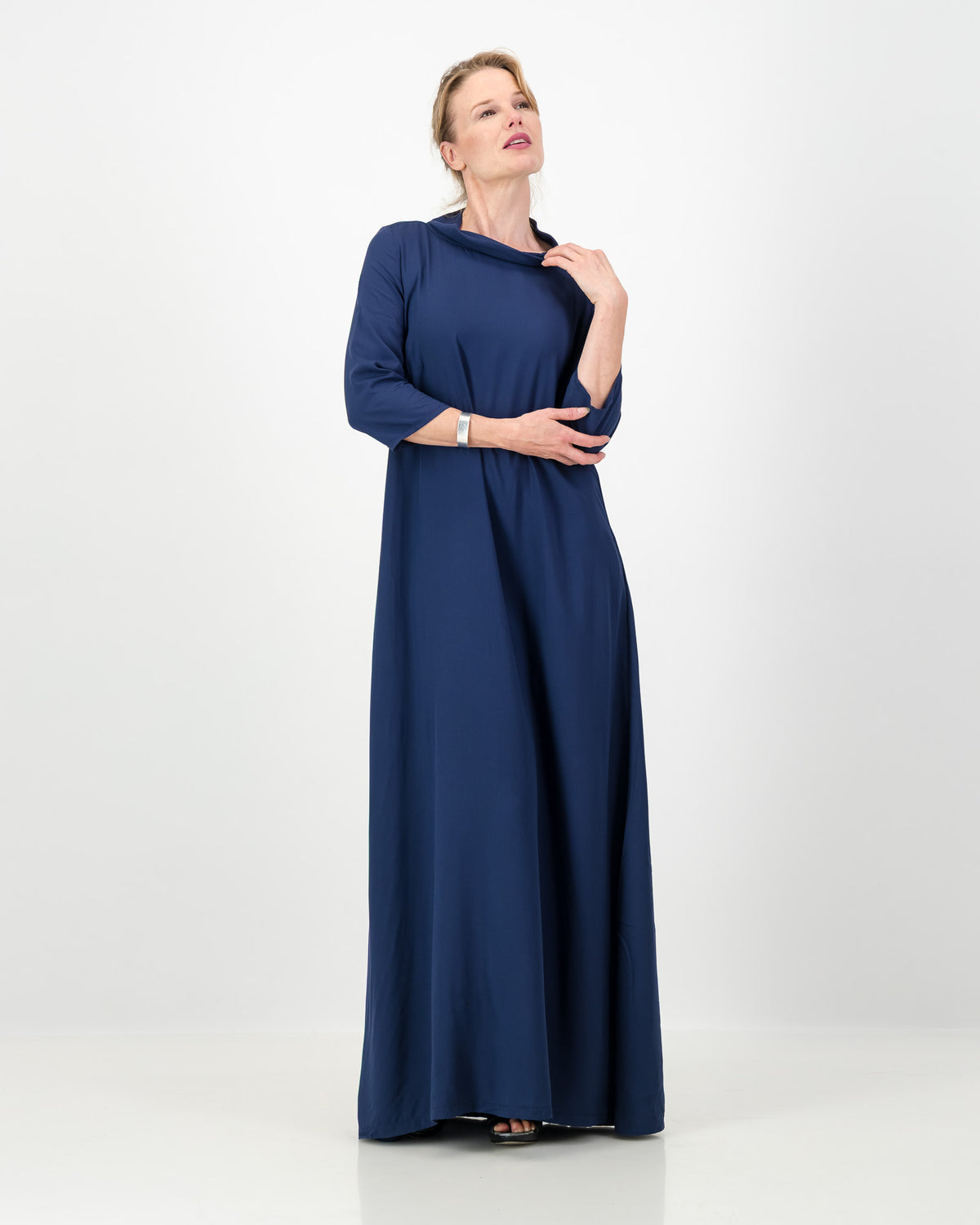 Woman wearing a long blue dress on a white background