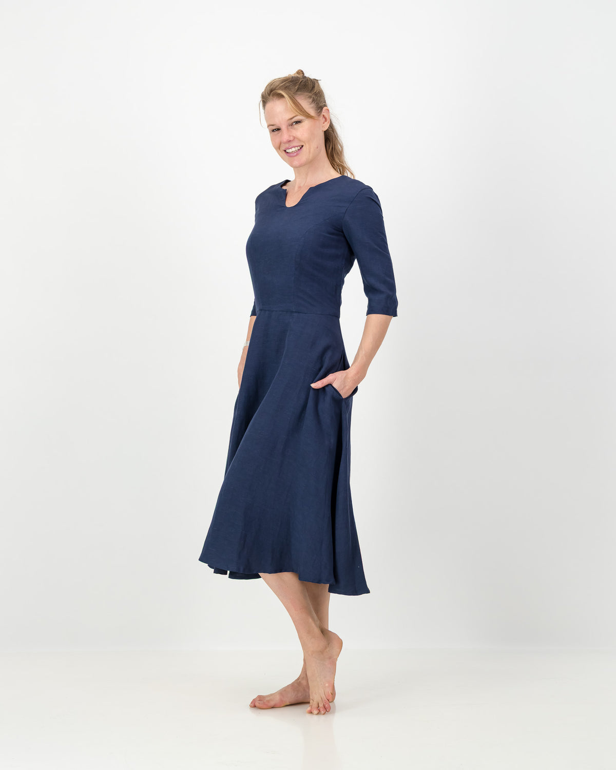 This image displays the LUNAR Khloe Dress in navy, highlighting its elegant and versatile design. The dress features a full, flattering knee-length skirt, a sophisticated keyhole neckline, and three-quarter sleeves, creating a stylish yet formal appearance.