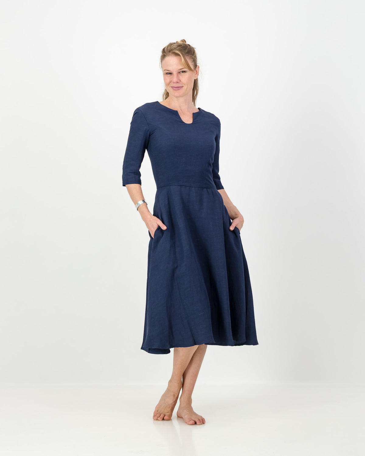 This image displays the LUNAR Khloe Dress in navy, highlighting its elegant and versatile design. The dress features a full, flattering knee-length skirt, a sophisticated keyhole neckline, and three-quarter sleeves, creating a stylish yet formal appearance.