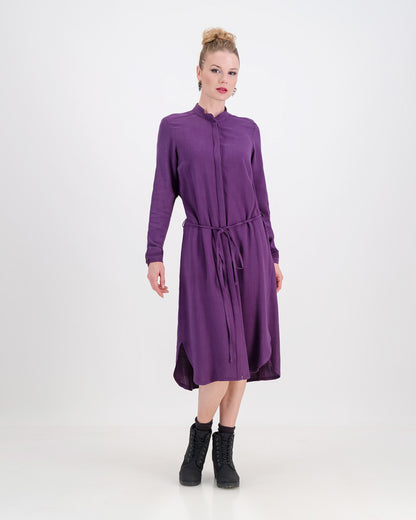 The deep purple imogen dress is shown here on a younger woman. She wears it effortlessly as the waist is cinched in with the built-in belt. The heavier linen/rayon blend fabric lets the dress fall beautifully and sits below the knee. The long sleeves of the dress can be worn ruched up or down depending on the weather.