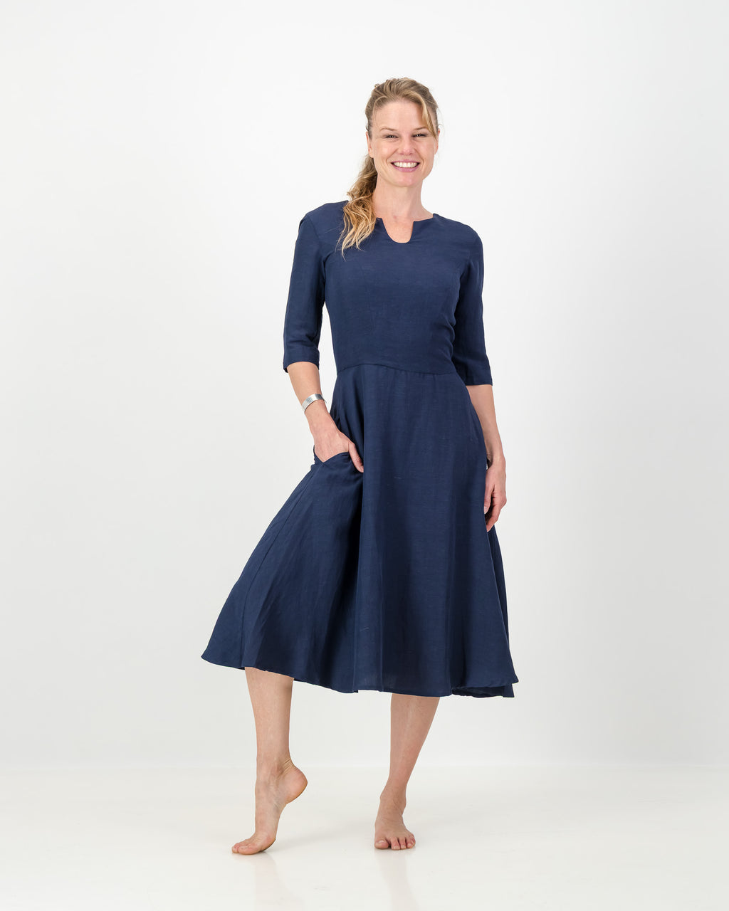 This image displays the LUNAR Khloe Dress in navy, highlighting its elegant and versatile design. The dress features a full, flattering knee-length skirt, a sophisticated keyhole neckline, and three-quarter sleeves, creating a stylish yet formal appearance.