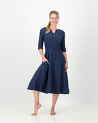 This image displays the LUNAR Khloe Dress in navy, highlighting its elegant and versatile design. The dress features a full, flattering knee-length skirt, a sophisticated keyhole neckline, and three-quarter sleeves, creating a stylish yet formal appearance.