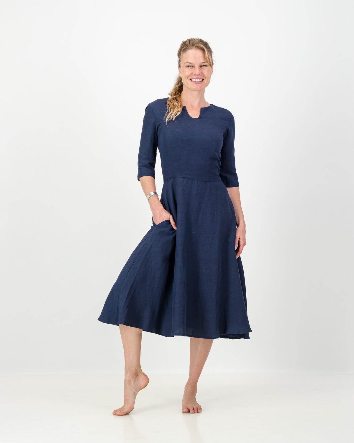 This image displays the LUNAR Khloe Dress in navy, highlighting its elegant and versatile design. The dress features a full, flattering knee-length skirt, a sophisticated keyhole neckline, and three-quarter sleeves, creating a stylish yet formal appearance.