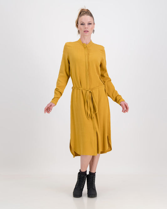 A lovely woman wears the imogen dress in mustard ochre, the autumnal tone is perfect for colder days. The dress has a concealed button stand and the rich linen/rayon blend fabric sits below the knee. The imogen also features long-sleeves that can be rolled up and ruched for a styling effect.