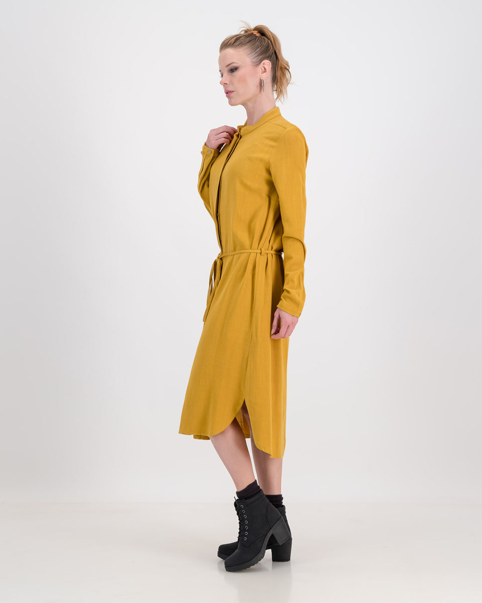 A lovely woman wears the imogen dress in mustard ochre, the autumnal tone is perfect for colder days. The dress has a concealed button stand and the rich linen/rayon blend fabric sits below the knee. The imogen also features long-sleeves that can be rolled up and ruched for a styling effect.