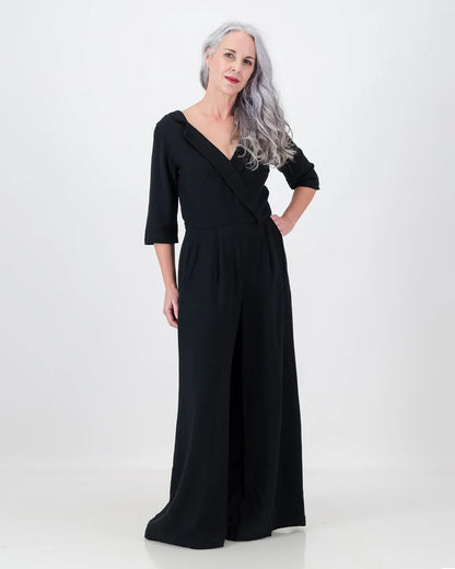 The gorgeous linen/rayon blend jojo jumpsuit is worn by a stunning distinguished woman with longer silver hair. The jojo jumpsuit can be worn casually or formally as it features a whimsical assymetrical collar and a wide leg shape.