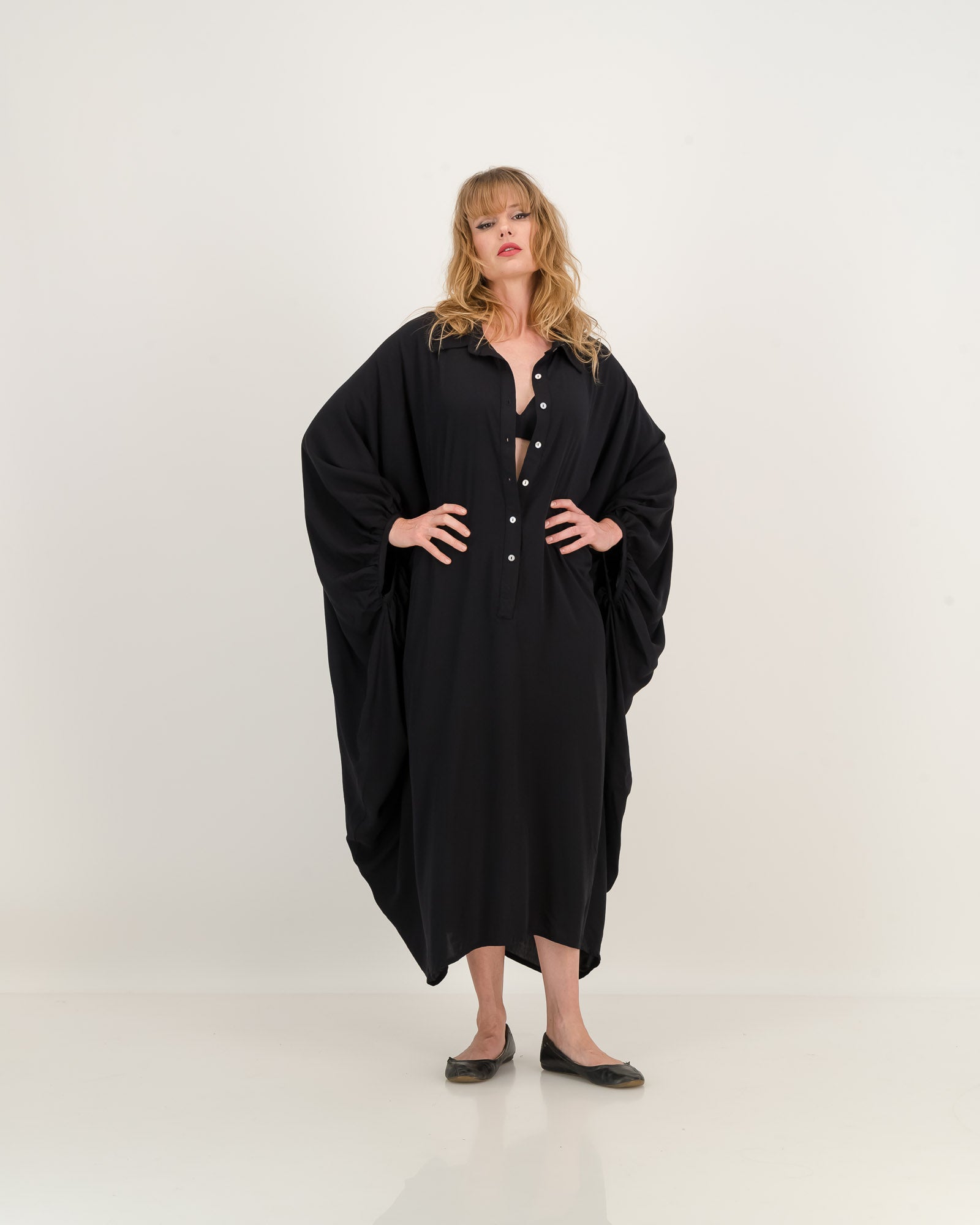 A black kaftan with dramatic batwing sleeve, featuring a relaxed fit, elegant details, and soft draping. Versatile for everyday or belted for a defined shape. Made from eco-friendly rayon.