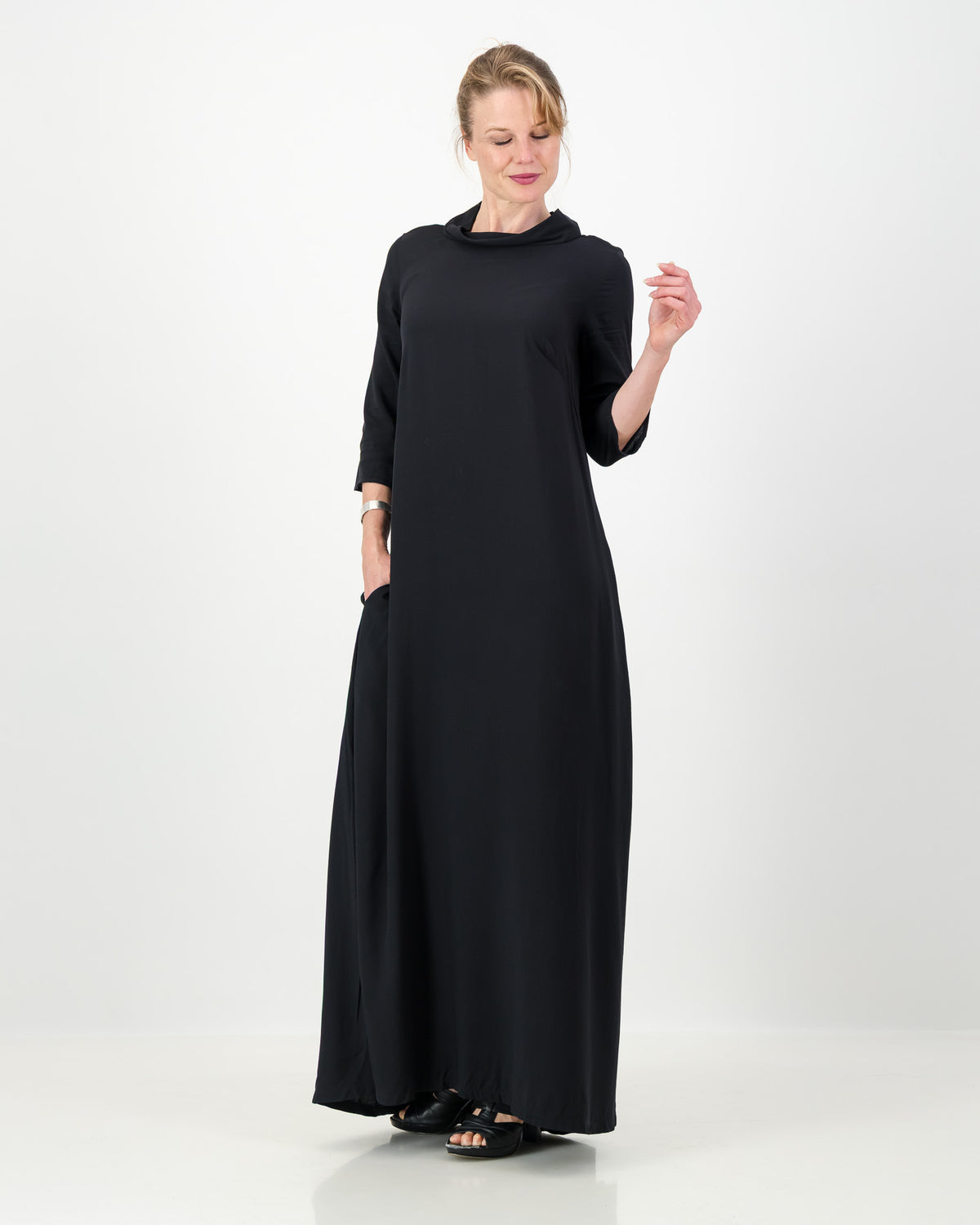 Woman wearing a long black dress on a white background
