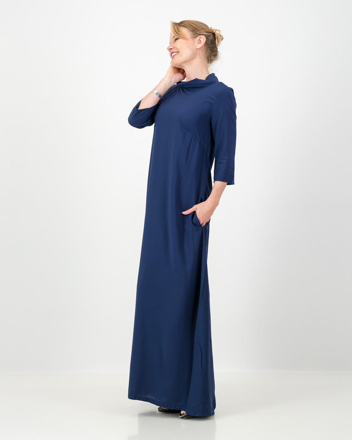 Woman wearing a long blue dress on a white background