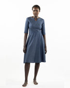 This image features a model wearing the "Khloe Dress" in a denim design. The dress, tailored with a flattering A-line silhouette, reaches below the knees, making it a versatile piece for both casual and semi-formal wear.