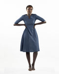 This image features a model wearing the "Khloe Dress" in a denim design. The dress, tailored with a flattering A-line silhouette, reaches below the knees, making it a versatile piece for both casual and semi-formal wear.