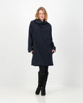 A black-colored winter dress with a cowl neckline, full-length sleeves, and a straight cut, worn by a lady with black boots and leggings.