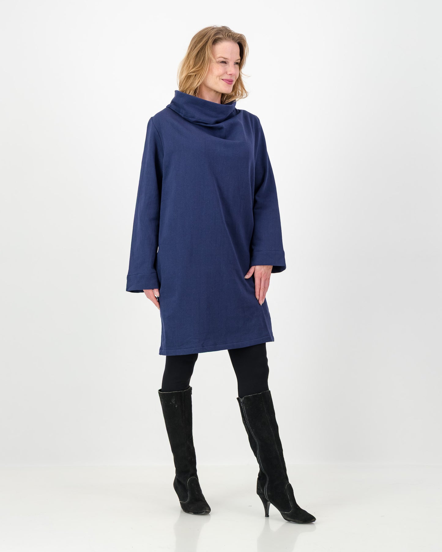 Woman wearing a blue dress with a cowl neck on a white background
