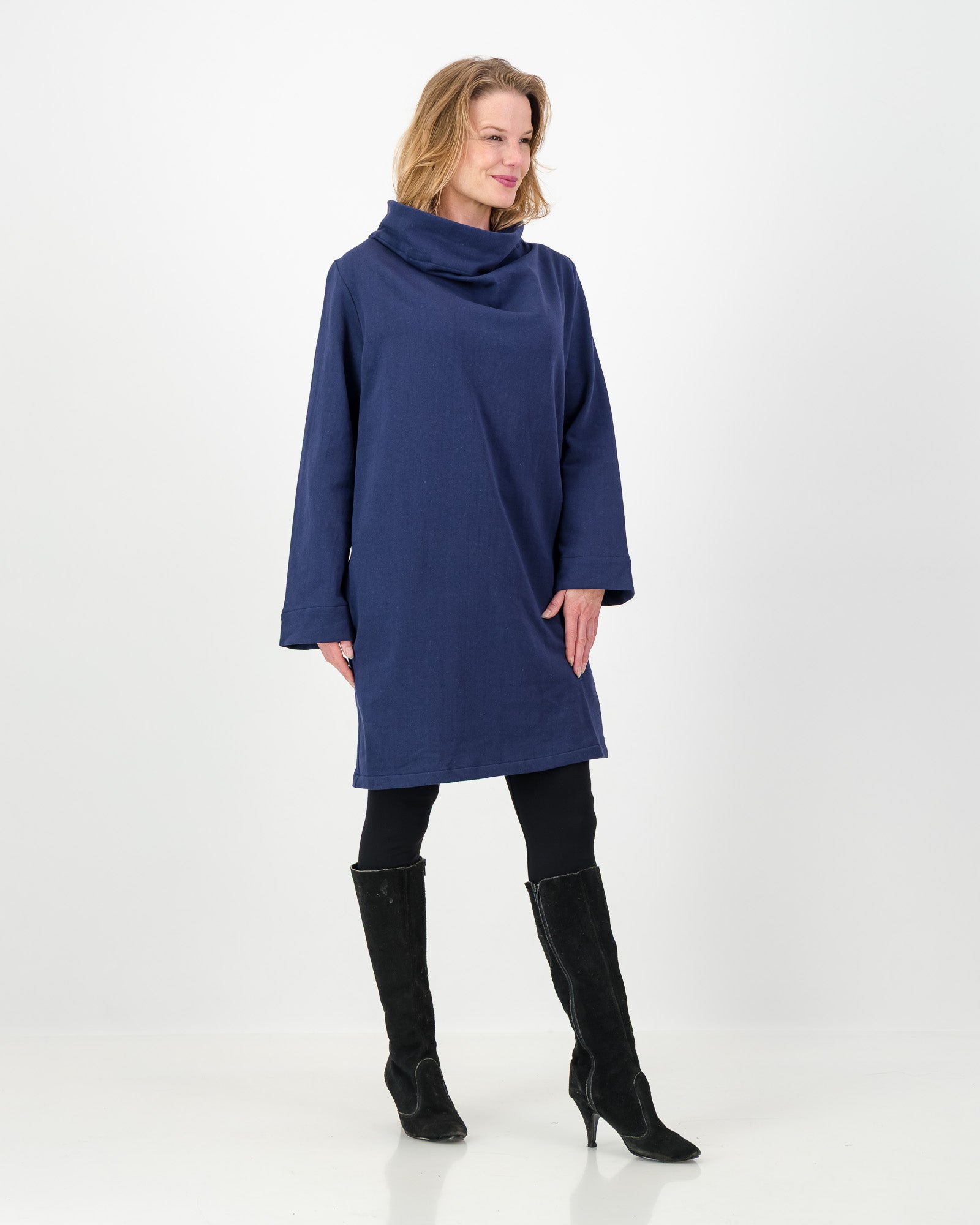 Woman wearing a blue dress with a cowl neck on a white background