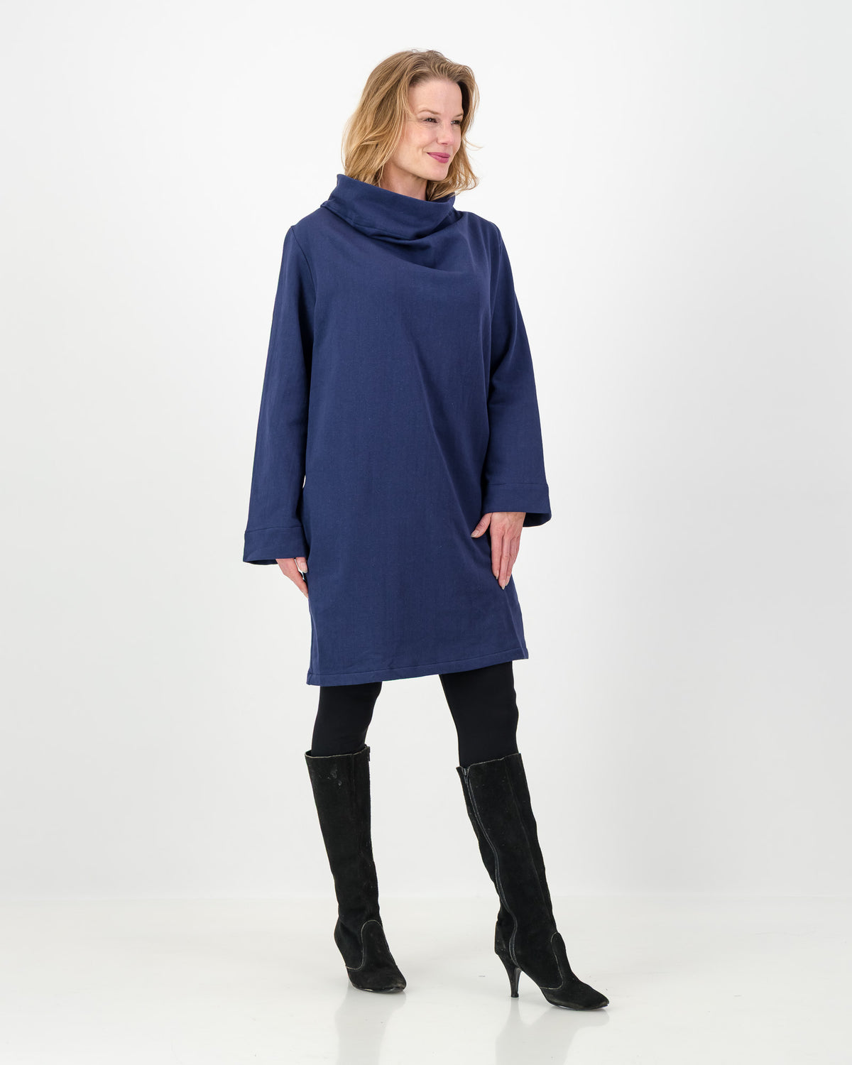 Woman wearing a blue dress with a cowl neck on a white background