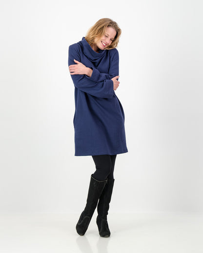 A navy-colored winter dress with a cowl neckline, full-length sleeves, and a straight cut, worn by a lady with black boots and leggings.