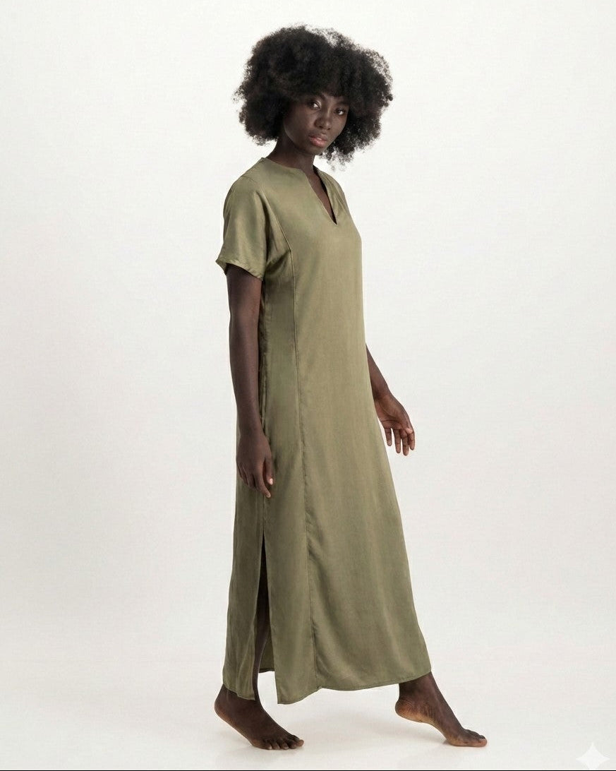 Woman wearing a long olive green dress on a white background